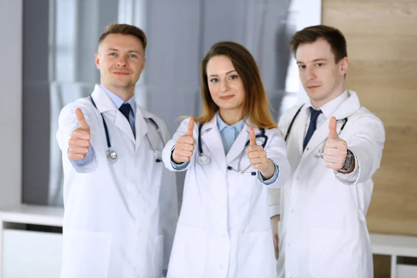 Modern orvosok csoportja áll, mint egy csapat hüvelykujj fel vagy Ok jel a kórházi irodában. Az orvosok készek megvizsgálni és segíteni a betegeken. Orvosi segítség, biztosítás az egészségügyben, legjobb kezelés és — Stock Fotó