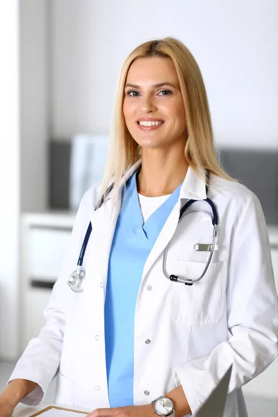 Läkare kvinna på jobbet på sjukhuset upphetsad och glad över sitt yrke. Blond läkare kontrollerar medicinering historia register och undersökningsresultat. Medicin och hälsovård — Stockfoto
