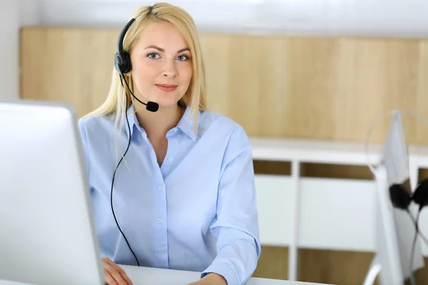 Call center. Blonde business woman sitting in headset at customer service office. Concept of telesales business or home office occupation