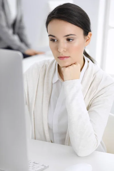 Деловая женщина в повседневной одежде работает с компьютером в офисе. Юрист или бухгалтер за работой — стоковое фото