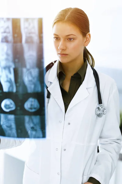 女医生在医院检查X光照片。在阳光灿烂的诊所工作的外科医生或矫形师。医药和保健概念 — 图库照片