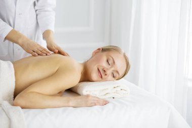 Güzel beyaz kadın gözleri kapalı sırt masajından hoşlanıyor. Güzellik ve Spa salonu konsepti