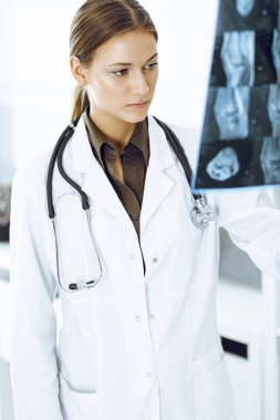 Kadın doktor hastanede röntgen filmini inceliyor. Ortopedist klinikte çalışıyor. Tıp ve sağlık hizmetleri kavramı