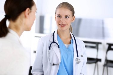 Muayene sırasında doktor ve hasta. Acil serviste portre çekimi yaparken ilaç geçmişini dolduran bir doktor. İlaç ve sağlık hizmetleri kavramı