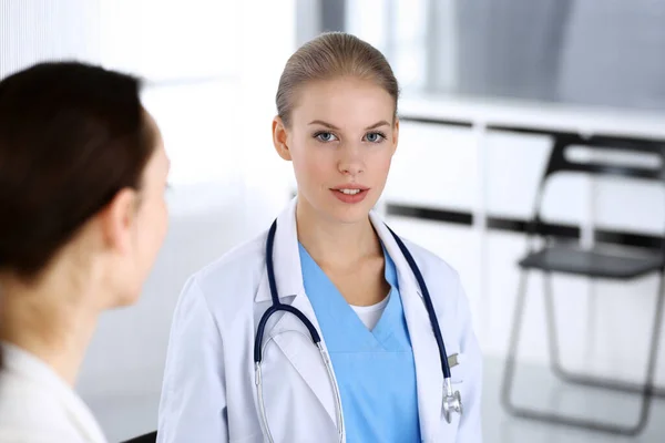 Doctor y paciente durante la consulta. Médico en el trabajo llenando el historial de medicamentos mientras está sentado en el hospital de emergencia, sesión de fotos. Concepto de medicina y salud —  Fotos de Stock