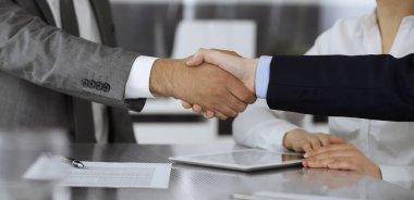 Başarılı bir müzakere olarak tokalaşma, yakın plan. Modern ofiste kontrat imzaladıktan sonra bilinmeyen iş adamları el sıkışıyor