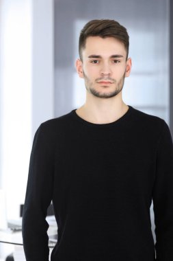 Modern ofiste sakallı adamın vesikalığı. İş adamı ya da öğrenci, dik durup gülümsüyor. Yaşam tarzı kavramı