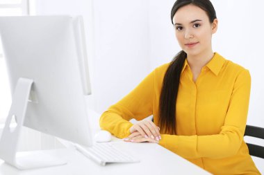 Ofiste bilgisayarla çalışan bir iş kadını. Masada otururken avukatın ya da muhasebecinin vesikalığı.