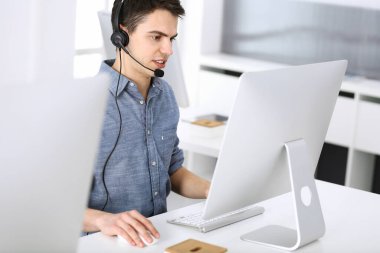 Bir grup operatör iş başında. Merkezi ara. Müşteri hizmetlerindeki genç resepsiyoniste odaklan. İş konsepti ve günlük giyim tarzı