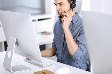 Bir grup operatör iş başında. Merkezi ara. Müşteri hizmetlerindeki genç resepsiyoniste odaklan. İş konsepti ve günlük giyim tarzı