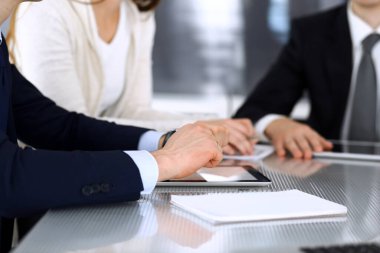 İş adamları modern ofisteki cam masasında birlikte çalışarak sözleşmeyi tartışıyor. İş arkadaşları ya da avukatları olan tanınmamış bir iş adamı ve kadın. Takım çalışması ve ortaklık