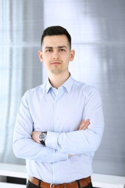 Ofisteki kameraya bakan bir iş adamı. Sıradan giyinen adamın vesikalığı.