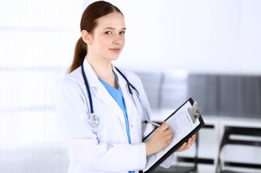 Doktor kadın ya da stajyer öğrenci. Acil serviste dururken ilaç geçmişini dolduran bir doktor. İlaç ve sağlık hizmetleri kavramı