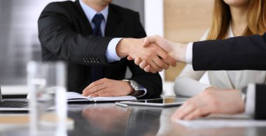 İş adamı, modern ofiste iş arkadaşı veya ortağıyla el sıkışıyor. Yakın plan. Toplantıda bilinmeyen iş adamları var. Takım çalışması, ortaklık ve el sıkışma kavramı