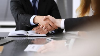 İş adamı, modern ofiste iş arkadaşı veya ortağıyla el sıkışıyor. Yakın plan. Toplantıda bilinmeyen iş adamları var. Takım çalışması, ortaklık ve el sıkışma kavramı