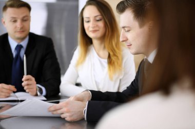 İş adamları ya da avukatlar modern ofiste soruları tartışıyorlar. Bilinmeyen iş adamı ve iş arkadaşı cam masada oturan ve çalışan bir kadın. Takım çalışması ve ortaklık kavramı