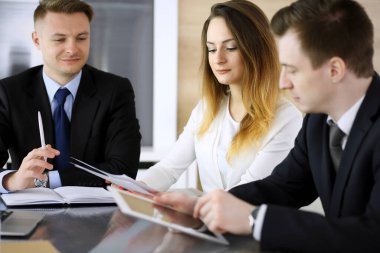 İş adamları ya da avukatlar modern ofiste soruları tartışıyorlar. Bilinmeyen iş adamı ve iş arkadaşı cam masada oturan ve çalışan bir kadın. Takım çalışması ve ortaklık kavramı