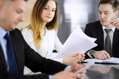 İş adamları ya da avukatlar modern ofiste soruları tartışıyorlar. Bilinmeyen iş adamı ve iş arkadaşı cam masada oturan ve çalışan bir kadın. Takım çalışması ve ortaklık kavramı