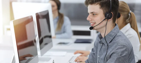 Call center. Group of casual dressed operators at work. Businessman in headset at customer service office. Telesales in business — Stock Photo, Image