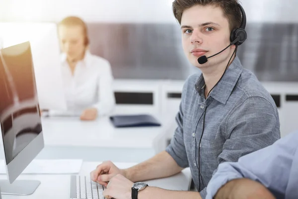 Call center. Group of casual dressed operators at work. Businessman in headset at customer service office. Telesales in business — Stock Photo, Image