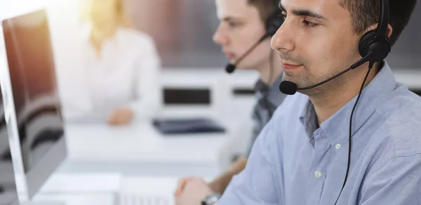 Call center. Group of casual dressed operators at work. Adult businessman in headset at customer service office. Telesales in business — Stock Photo, Image