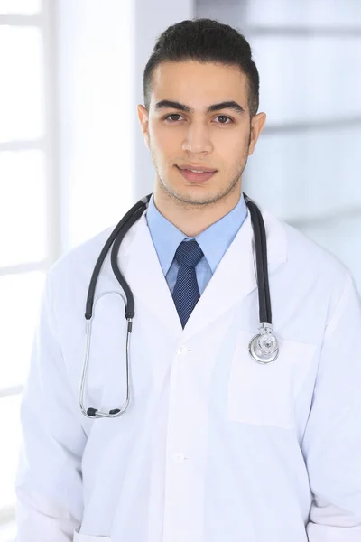 Médico árabe de pie en consultorio médico o clínica. Retrato médico o foto en la cabeza. Concepto de medicina y salud — Foto de Stock