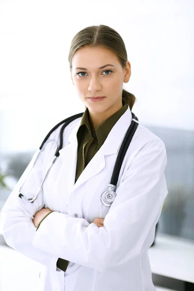 Doctora de pie recta y mirando a la cámara. Servicio médico perfecto en la clínica. Futuro feliz en medicina y salud — Foto de Stock