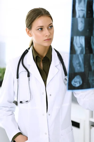 Docteur femme examinant une photo radiographique à l'hôpital. Chirurgien ou orthopédiste au travail en clinique. Médecine et concept de santé — Photo