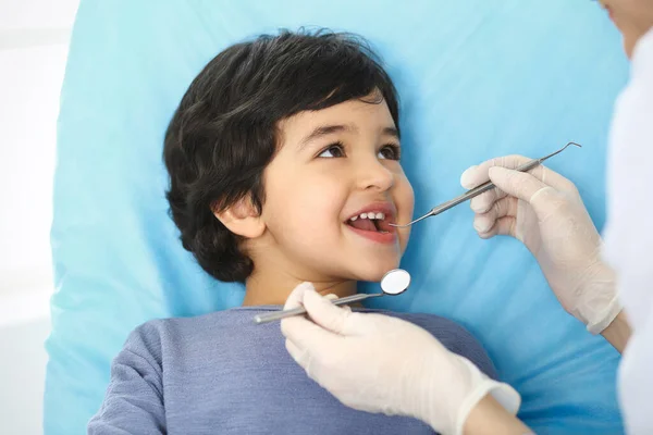 医生进行口腔检查时，坐在牙椅上张开嘴的阿拉伯小男孩。去看牙医医学和口腔医学概念 — 图库照片