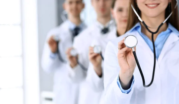 Steteskop tutan bir grup doktor. Doktorlar hastaları muayene etmeye ve yardım etmeye hazır. Tıbbi yardım, sağlık sigortası, en iyi tedavi ve tıp konsepti