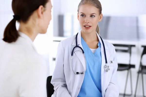 Doctor y paciente durante la consulta. Médico en el trabajo llenando el historial de medicamentos mientras está sentado en el hospital de emergencia, sesión de fotos. Concepto de medicina y salud — Foto de Stock