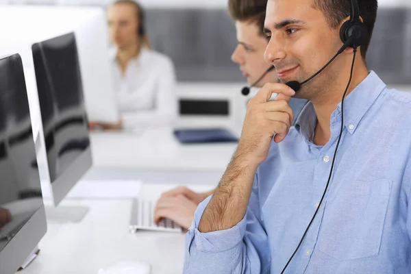 Call center. Group of casual dressed operators at work. Focus on adult businessman in headset at customer service office. Telesales in business — Stock Photo, Image