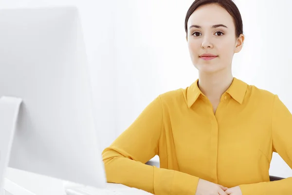 Mujer de negocios en blusa de color mostaza mirando a la cámara en la oficina, foto en la cabeza —  Fotos de Stock