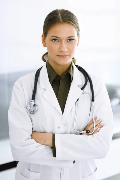 Mujer-médico de pie con los brazos cruzados y mirando a la cámara. Servicio médico perfecto en la clínica. Medicina y asistencia sanitaria — Foto de Stock