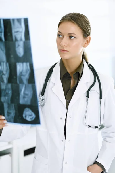 Kvinna-läkare undersöker röntgenbild på sjukhus. Kirurg eller ortoped på jobbet på kliniken. Medicin och hälsovård — Stockfoto