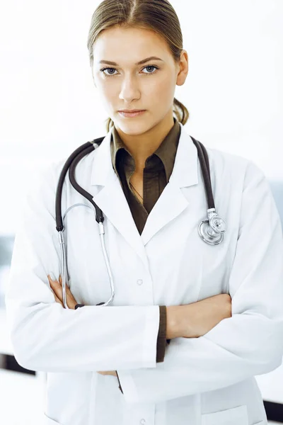 Mujer-médico de pie con los brazos cruzados y mirando a la cámara. Medicina y asistencia sanitaria — Foto de Stock