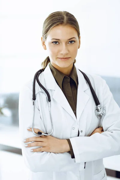 Žena-doktorka stojí se založenýma rukama a dívá se do kamery. Léky a zdravotní péče — Stock fotografie