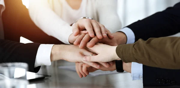 Gente de negocios grupo mostrando el trabajo en equipo y la unión de manos o dar cinco en la oficina soleada. Hombre de negocios y mujeres desconocidos haciendo círculo con sus manos — Foto de Stock