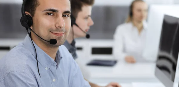 Centro de llamadas. Grupo de operadores vestidos casuales en el trabajo. Hombre de negocios adulto con auriculares en la oficina de servicio al cliente. Telesales en el negocio —  Fotos de Stock