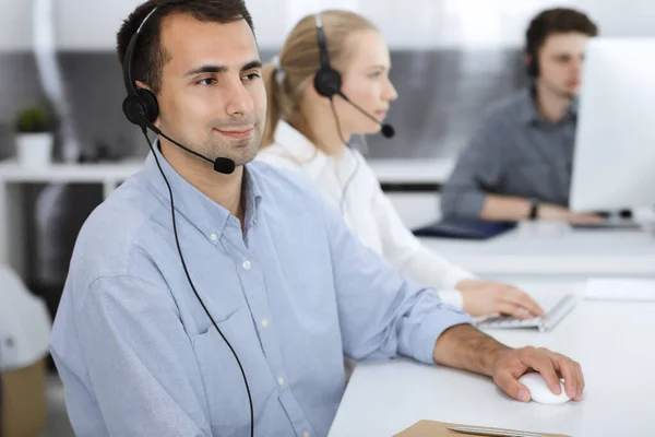 Centro de llamadas. Grupo de operadores vestidos casuales en el trabajo. Hombre de negocios adulto con auriculares en la oficina de servicio al cliente. Telesales en el negocio —  Fotos de Stock