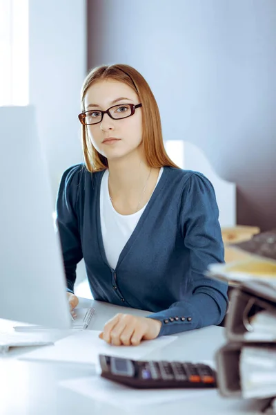 Contabilista verificando ficha financeira ou contando por calculadora de renda para a forma de imposto, mãos close-up. Mulher de negócios sentada e trabalhando na mesa no escritório. Conceito de auditoria — Fotografia de Stock