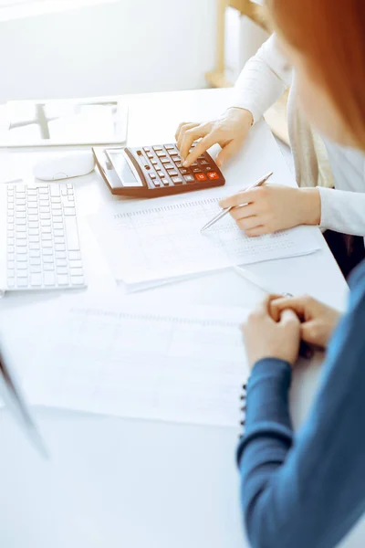 Contador que comprueba el estado financiero o cuenta por la renta de la calculadora para el formulario de impuestos, manos de cerca. Mujer de negocios sentada y trabajando con un colega en el escritorio de la oficina. Concepto de auditoría — Foto de Stock