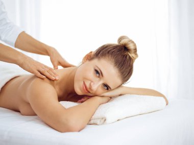 Genç ve sarışın kadın masaj salonunun keyfini çıkarıyor. Güzellik konsepti