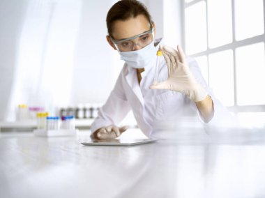 Kadın laboratuvar asistanı hastanede kan örneğini inceliyor. Tıp, sağlık ve araştırma konsepti