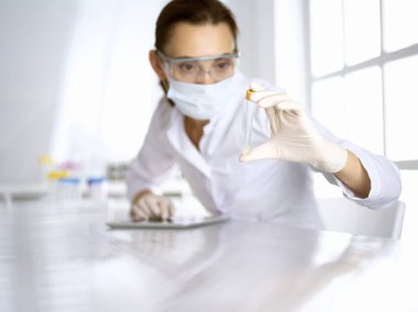 Kadın laboratuvar asistanı hastanede kan örneğini inceliyor. Tıp, sağlık ve araştırma konsepti