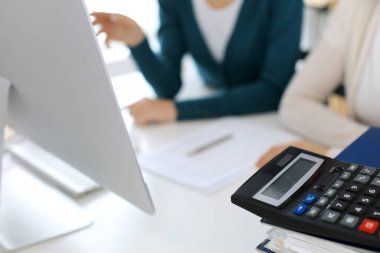 Hesap makinesi ve kağıtlar iş kadını ya da ofisteki büroda çalışan muhasebeci tarafından incelenmeyi bekliyor. İç Denetim ve vergi kavramı