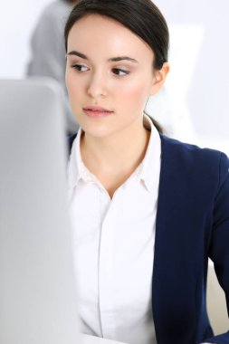 Ofiste bilgisayarla çalışan bir iş kadını, arka planda çalışan bir iş arkadaşı. Masada otururken avukatın ya da muhasebecinin vesikalığı.