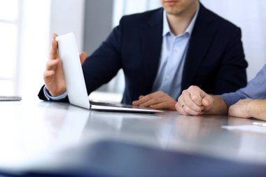 Modern ofiste birlikte çalışırken dizüstü bilgisayarı kullanan iş adamları. İş yerinde iş arkadaşı olan tanınmamış bir iş adamı ya da erkek girişimci. Takım çalışması ve ortaklık kavramı