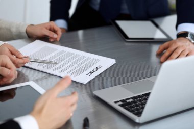 İş adamları modern ofisteki cam masasında birlikte çalışarak sözleşmeyi tartışıyor. İş arkadaşları ya da avukatları olan tanınmamış bir iş adamı ve kadın. Takım çalışması ve ortaklık