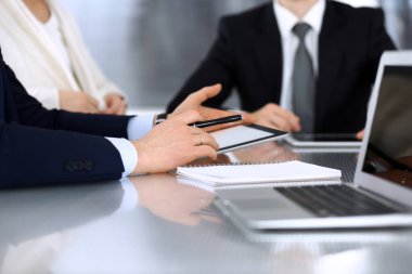 İş adamları modern ofisteki cam masasında birlikte çalışarak sözleşmeyi tartışıyor. İş arkadaşları ya da avukatları olan tanınmamış bir iş adamı ve kadın. Takım çalışması ve ortaklık